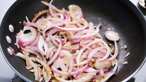 Onions, garlic, and Sichuan pepper sautéing for Ema Datshi