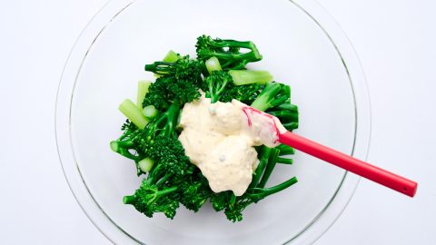 Mixing dressing and broccolini for Broccolini with Smoked Salmon and Eggs