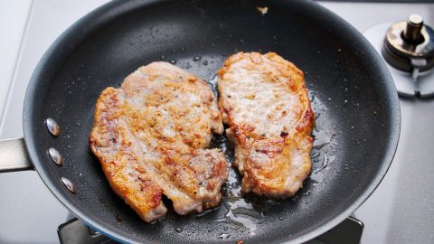 Maple Mustard Glazed Pork Chops frying in a pan.