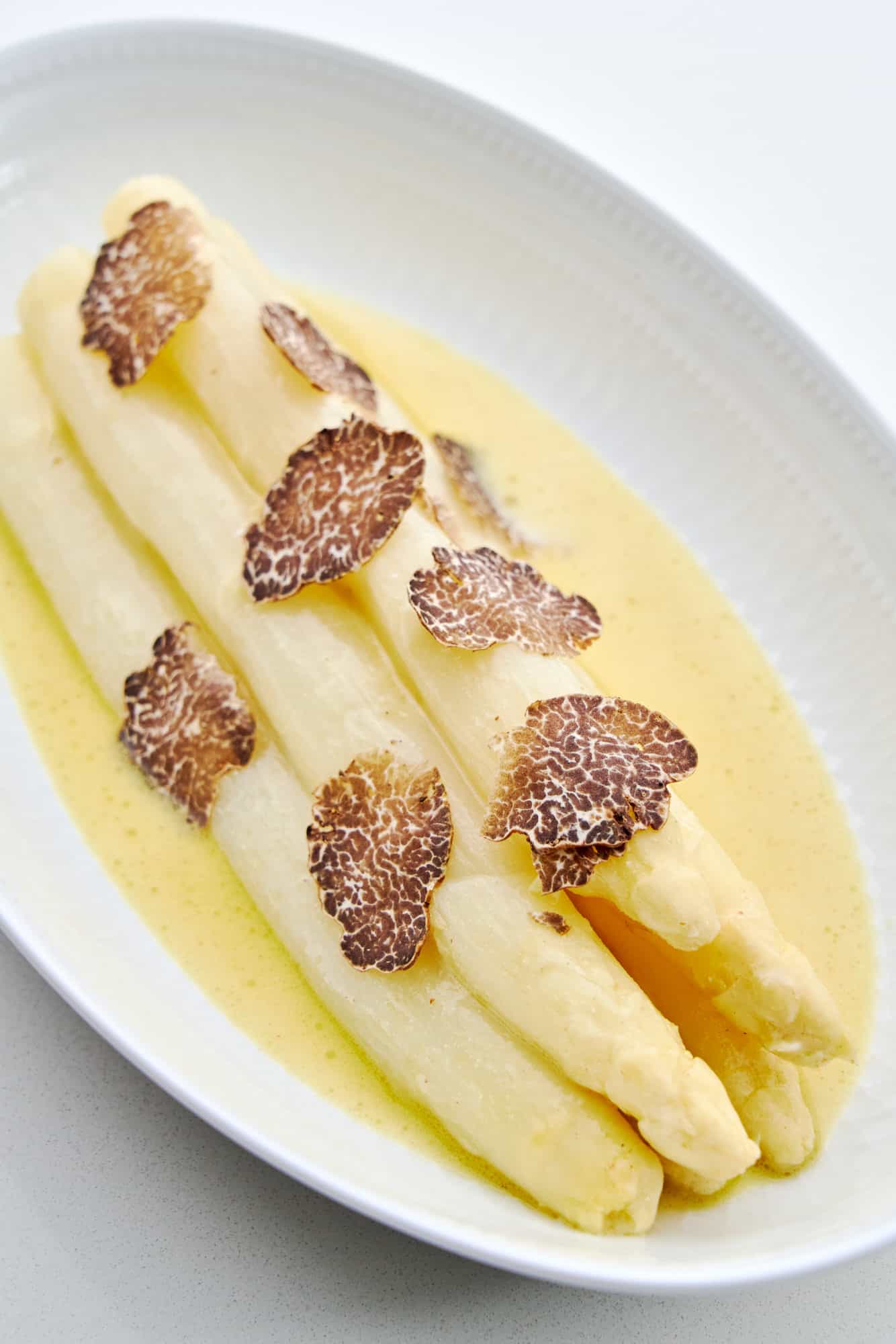 Aspragus marinated in a tangy mustard emulsion with shaved bianchetto truffles.
