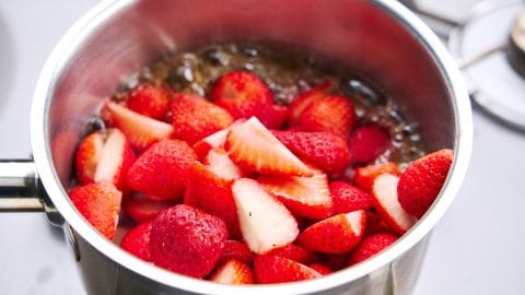 Adding the strawberries to the caramelized sugar for Strawberry Preserves.