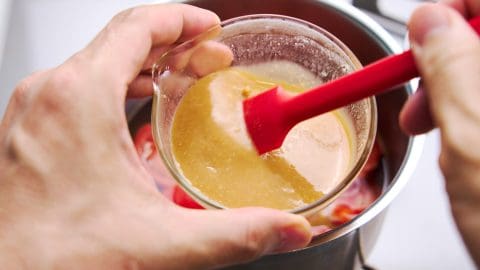 Disolving miso paste in dashi with a spatula.