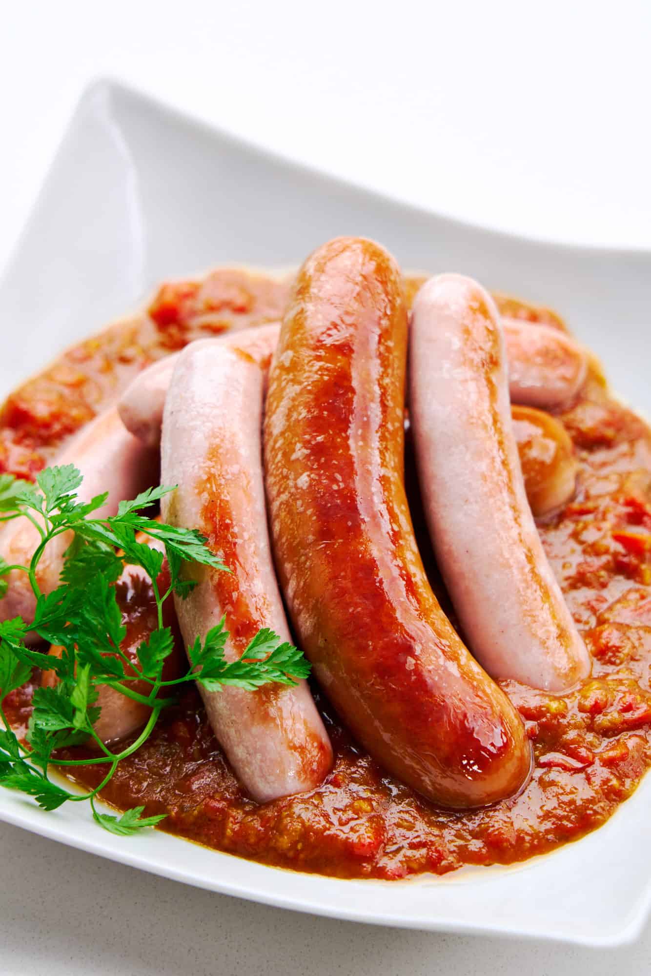 Pan-fried sausages with a sweet and spicy tomato curry sauce.