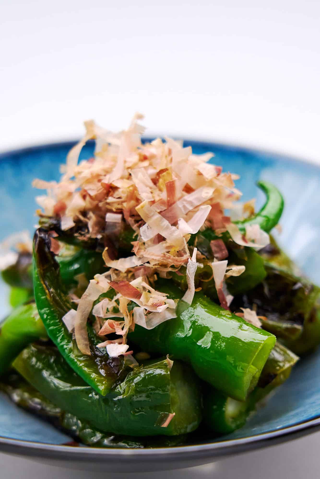 Grilled manganji peppers seasoned with olive oil and lemon juice, topped with katsuobushi.
