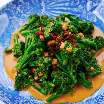 A plate of broccoli dressed with a spicy peanut sauce.