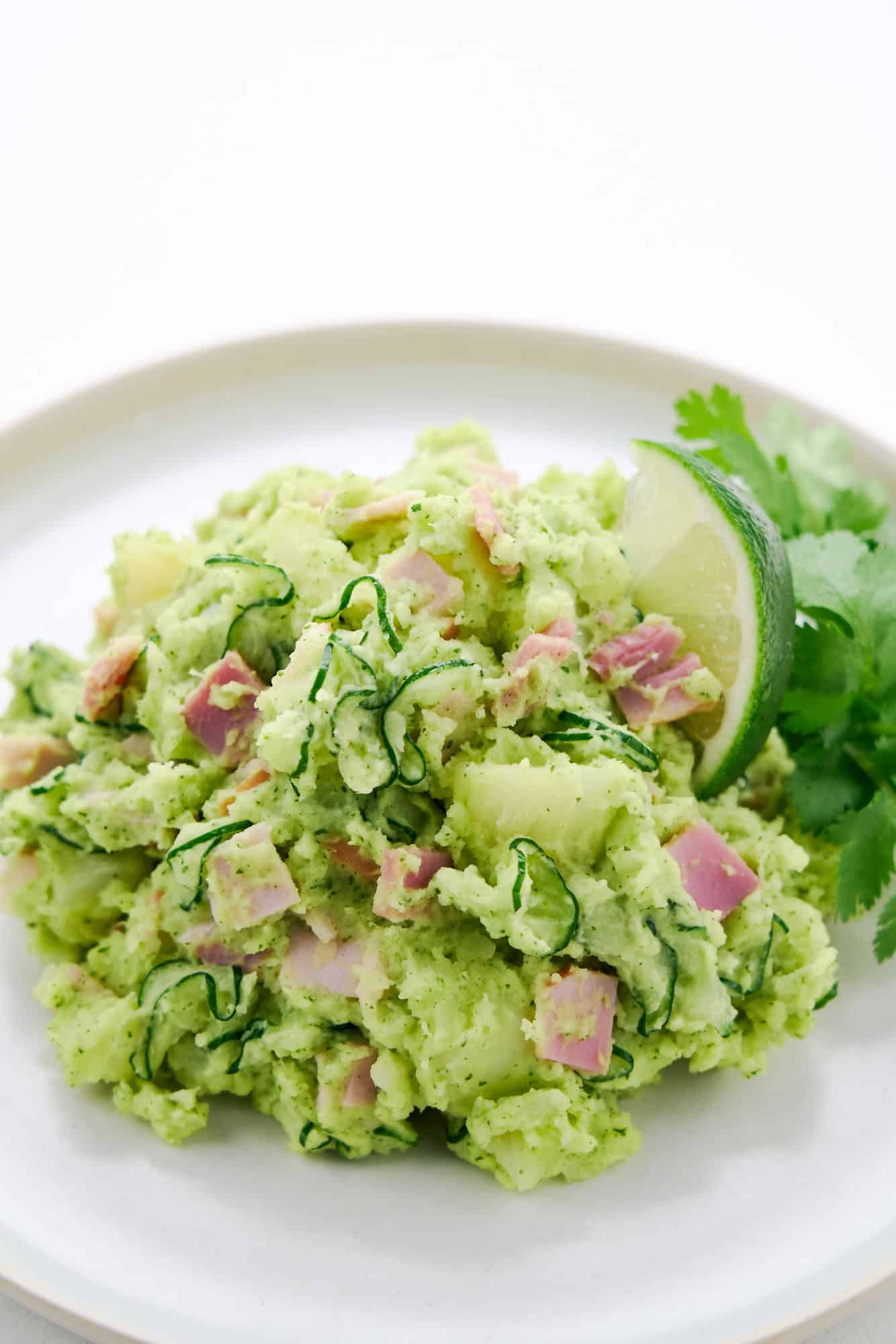 Potato salad with cilantro and a wedge of lime.