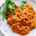 A plate of shrimp in a tomato curry sauce.