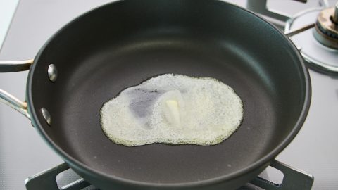 A frying pan with butter melting in it.