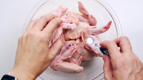 Wings get sprinkled with salt and pepper before resting in the refrigerator overnight.