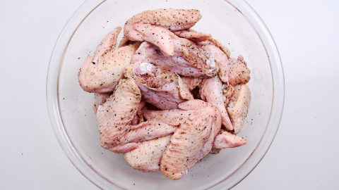 Chicken wings sprinkled with salt and pepper.