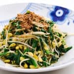 A bowl of stir fried bean sprouts with sesame seeds.