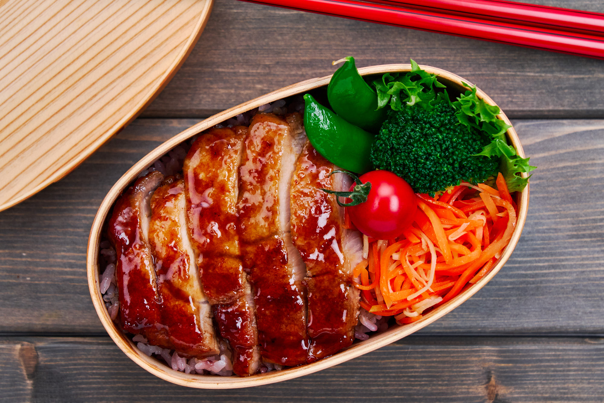 Carrot salad packed in a ginger pork teriyaki bento.