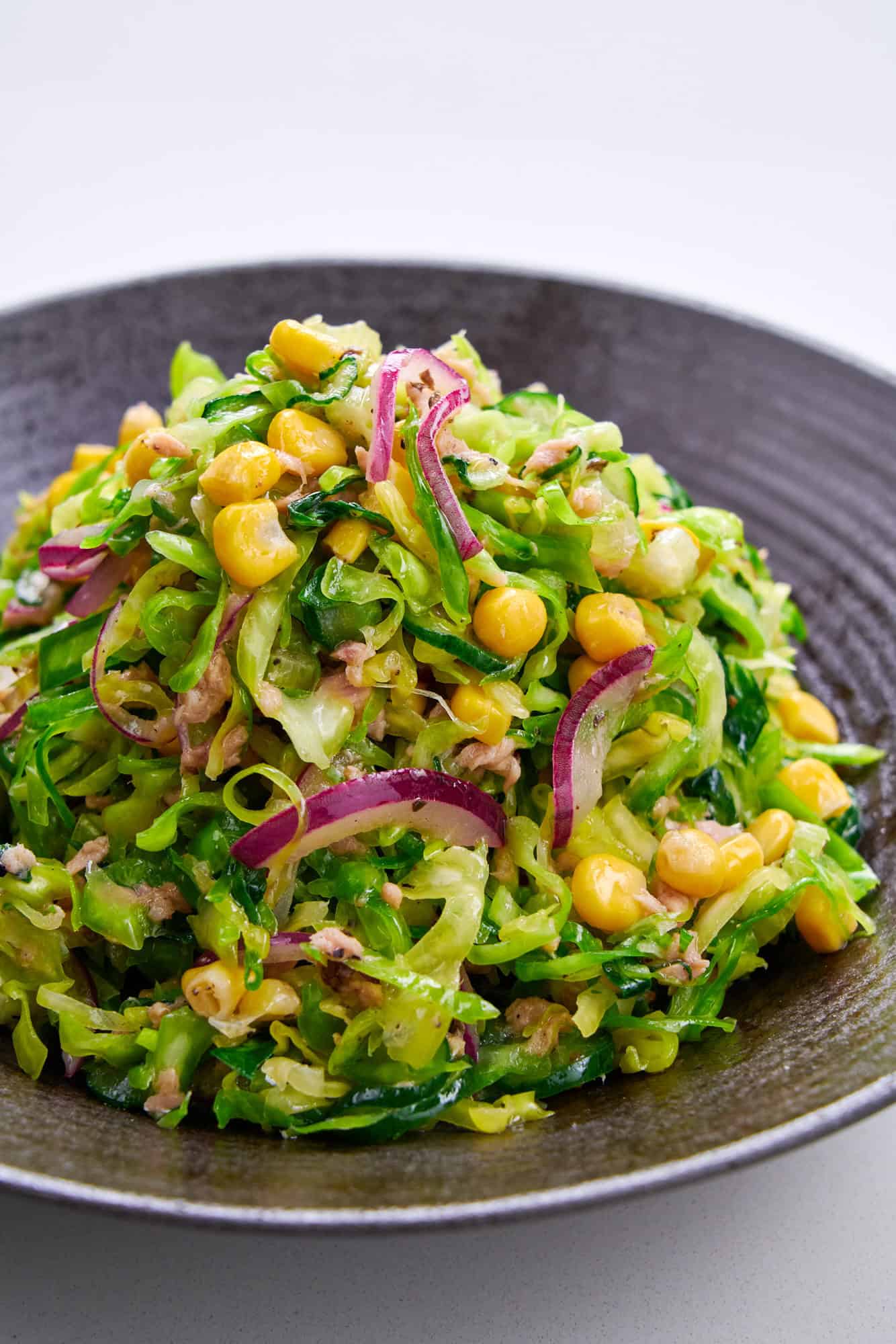 A mound of colorful vegetables and cabbage in a tangy dressing.