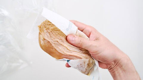 Wiping off excess marinade.