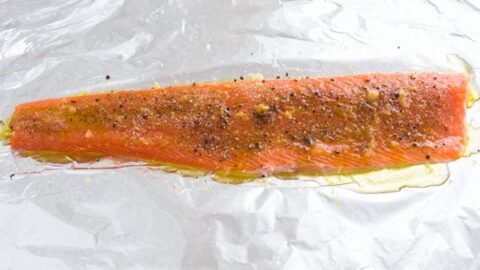 Seasoned salmon fillet on foil.