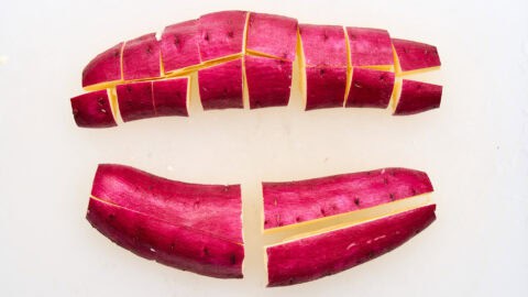 Cutting Japanese sweet potatoes into segments.