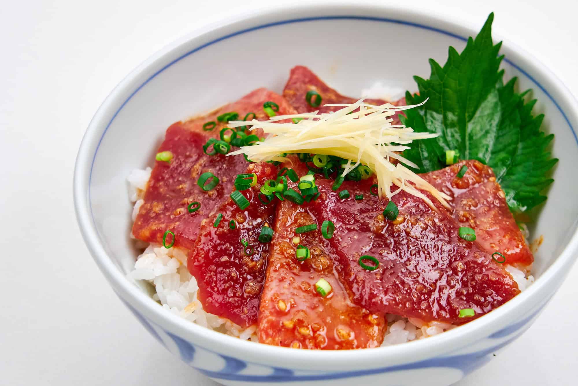 Sliced and marinated tuna in a bowl with rice.