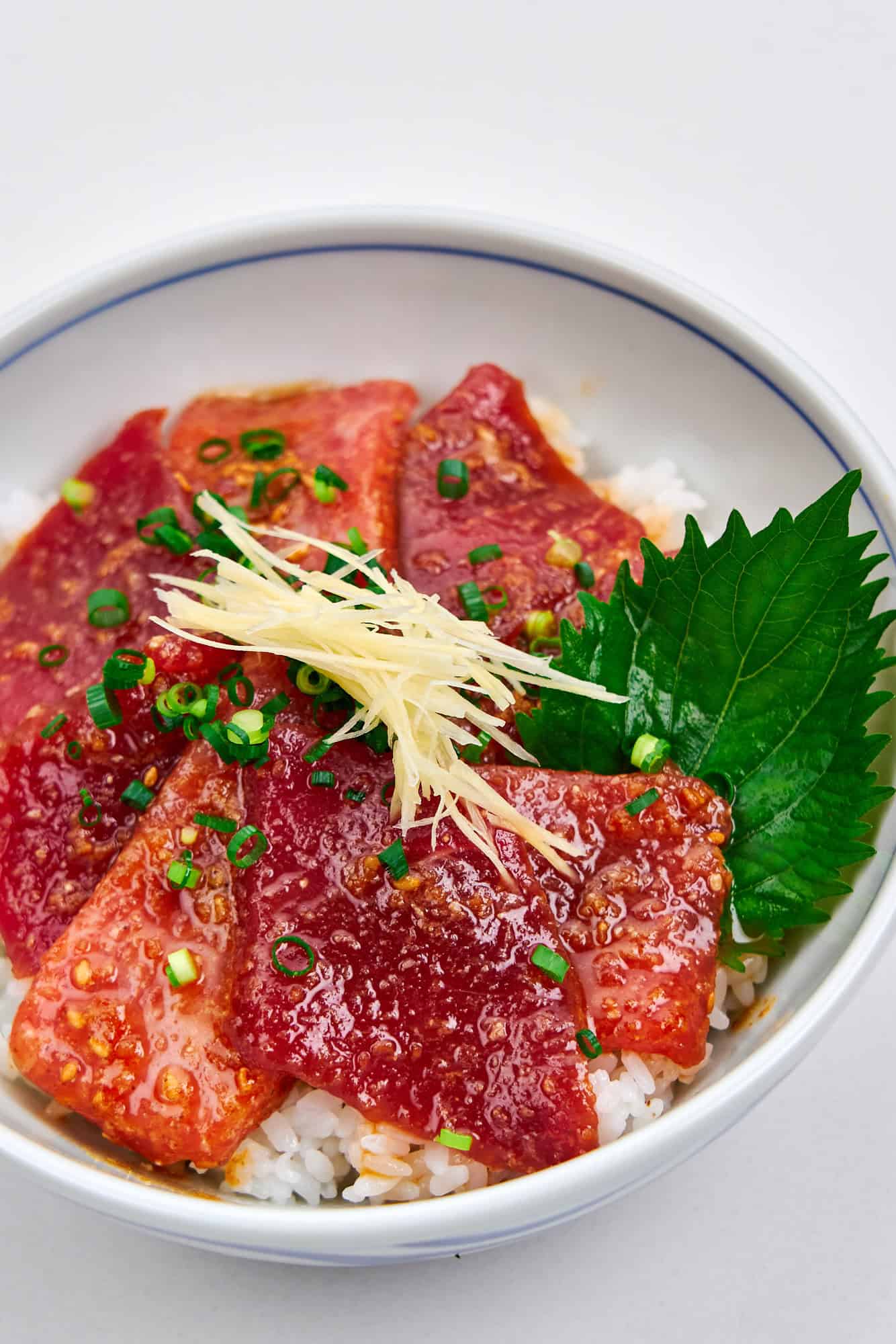 Closeup of sliced and marinated tuna in a bowl with rice.