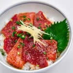 Sliced and marinated tuna in a bowl with rice.