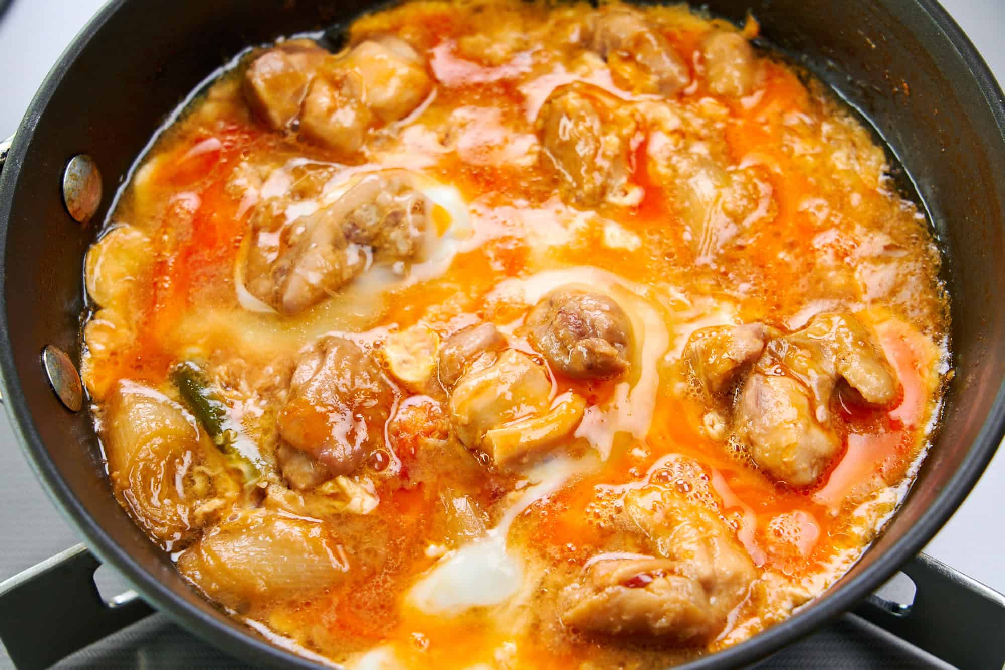 Freshly poured egg enrobes the chicken and Tokyo negi.