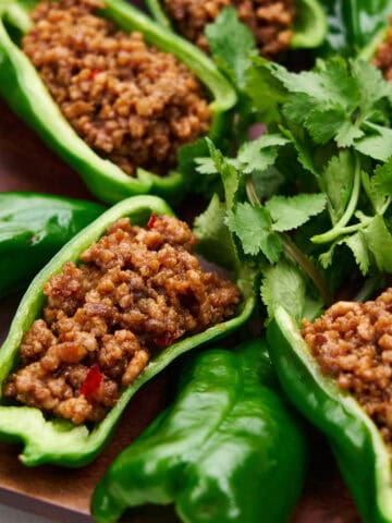 Spicy stuffed peppers arranged on a square platter.