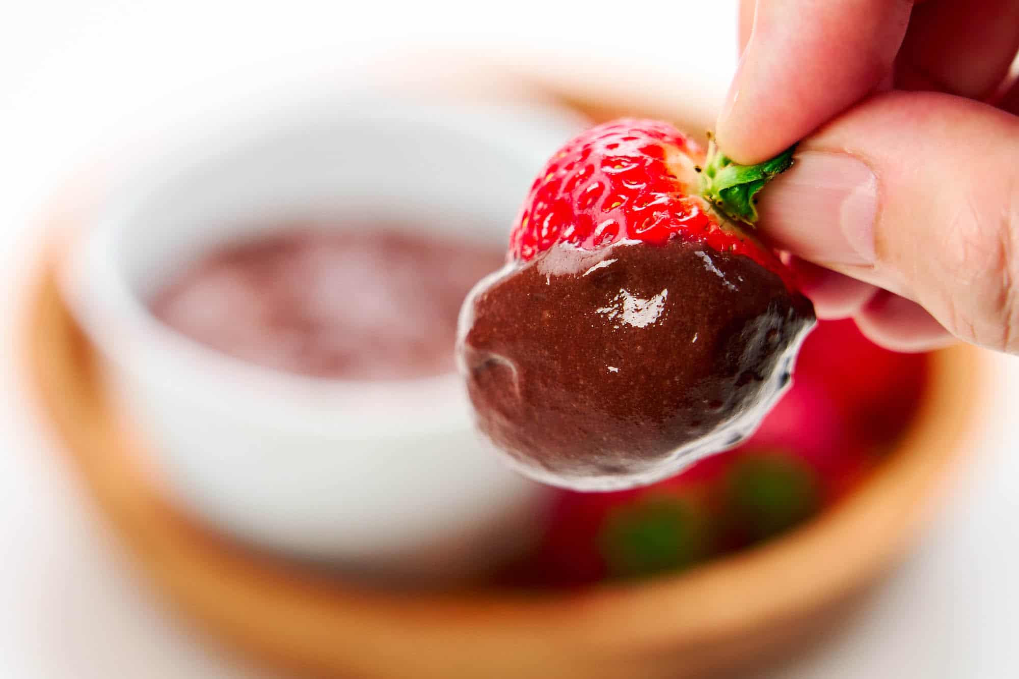 A strawberry enrobed in chocolate konjac pudding.