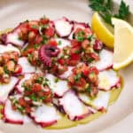 Cooked octopus dressed with tomato, onion, lemon and olive oil.