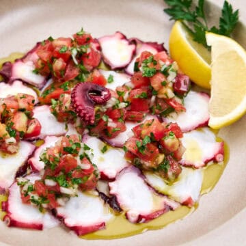 Cooked octopus dressed with tomato, onion, lemon and olive oil.
