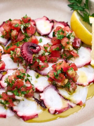 Cooked octopus dressed with tomato, onion, lemon and olive oil.