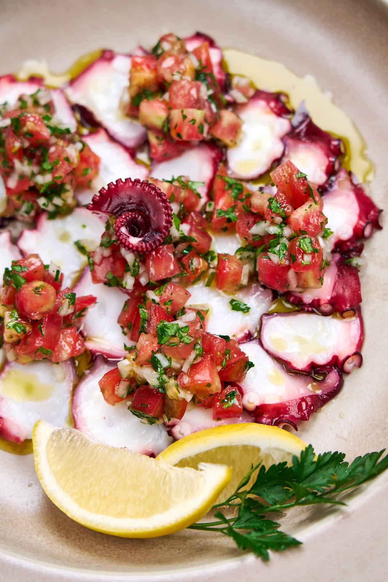 Cooked octopus dressed with tomato, onion, lemon and olive oil.
