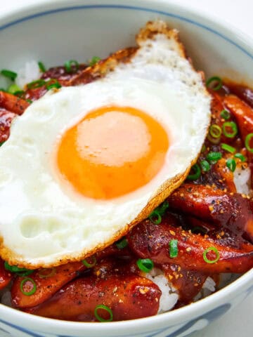 Smoked sausage, egg and rice in a bowl with scallions.
