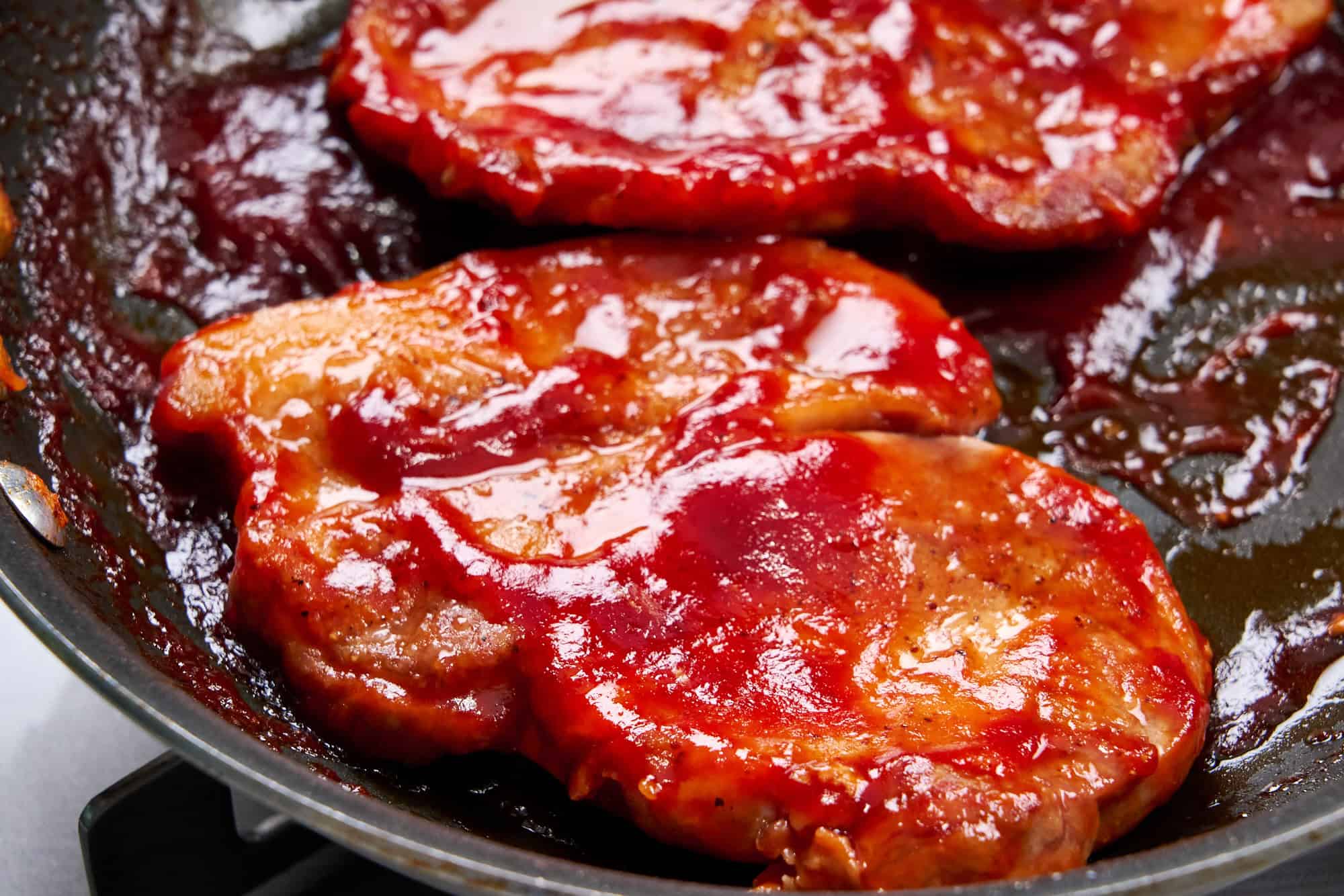 Pork chops absorbing the tangy glaze.