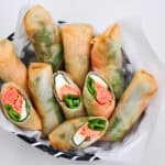 Delicately crispy Mentaiko Cheese Spring Rolls in a basket.