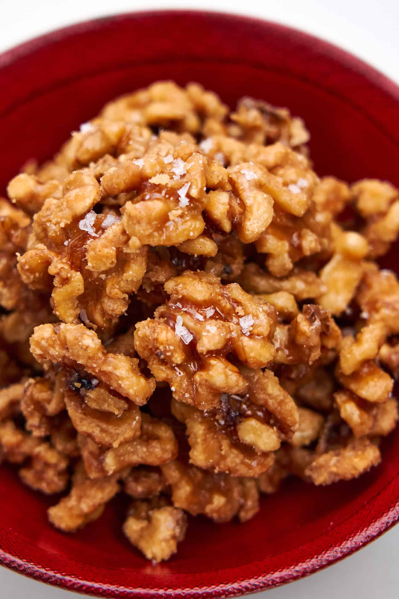 Maple Candied Walnuts arranged in a red lacquer bowl.