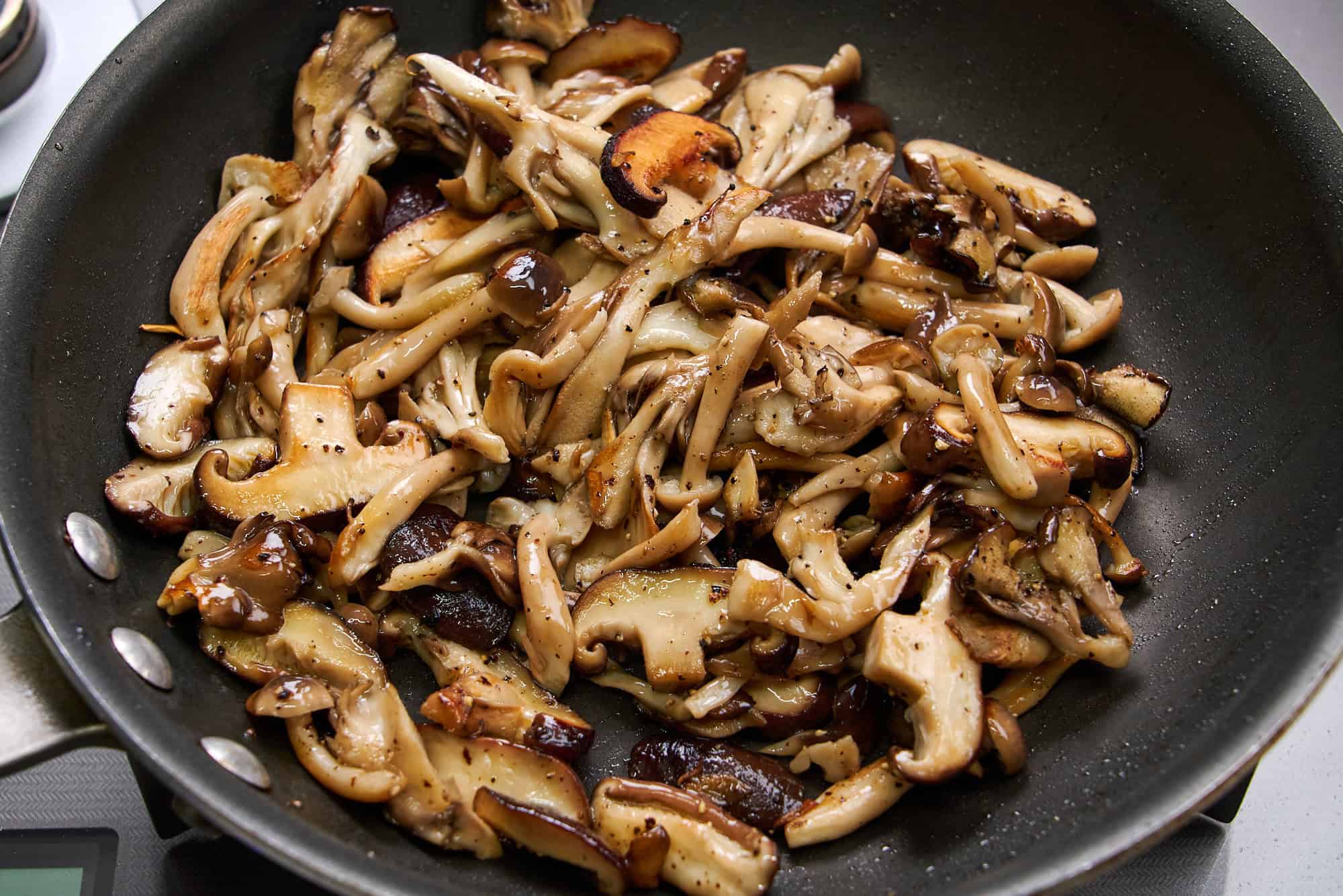 Sautéing mushrooms until golden brown.