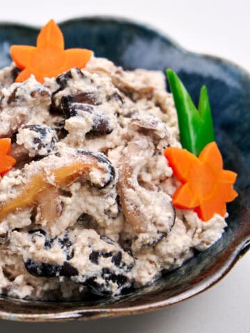 Mushroom shira-ae in a black bowl with maple leaf carrots.