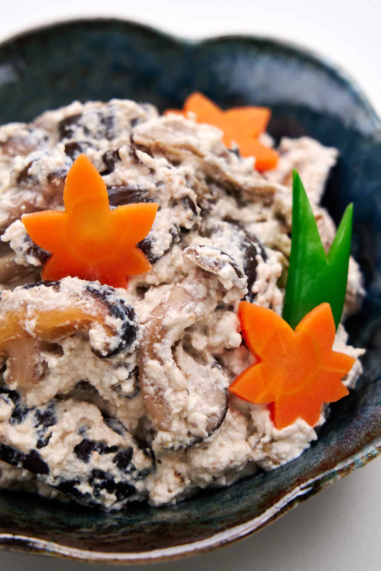 Mushroom shira-ae in a black bowl with maple leaf carrots.